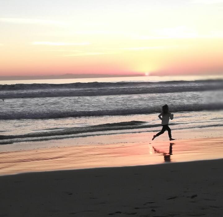 A swimmer on the beach at sunset along the Sea of Cortez