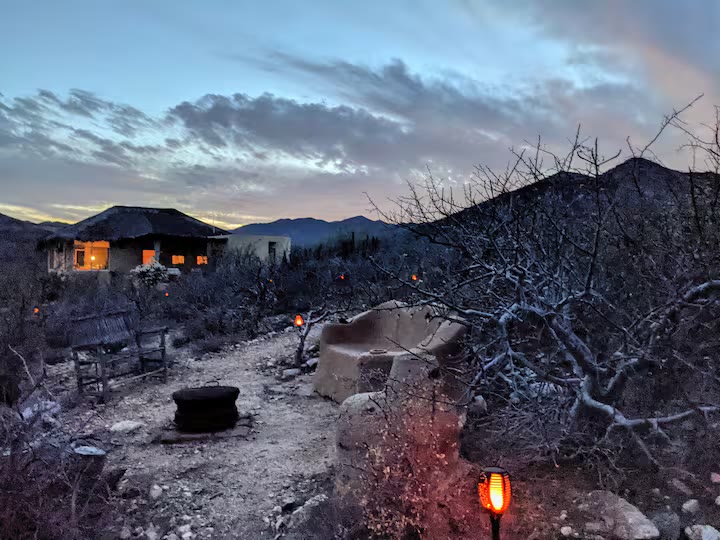 The casita at twilight, with desert in the foreground and mountains behind
