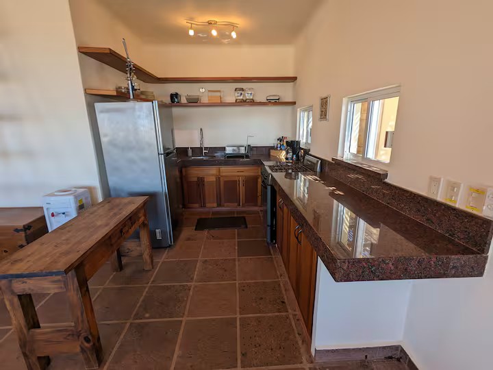 Compact full kitchen with stove, refrigerator, and counter space