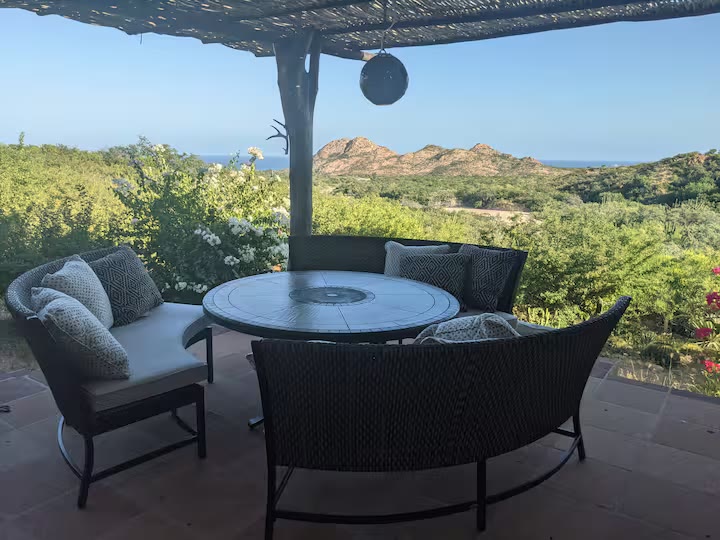 Outdoor dining table under palapa with desert view
