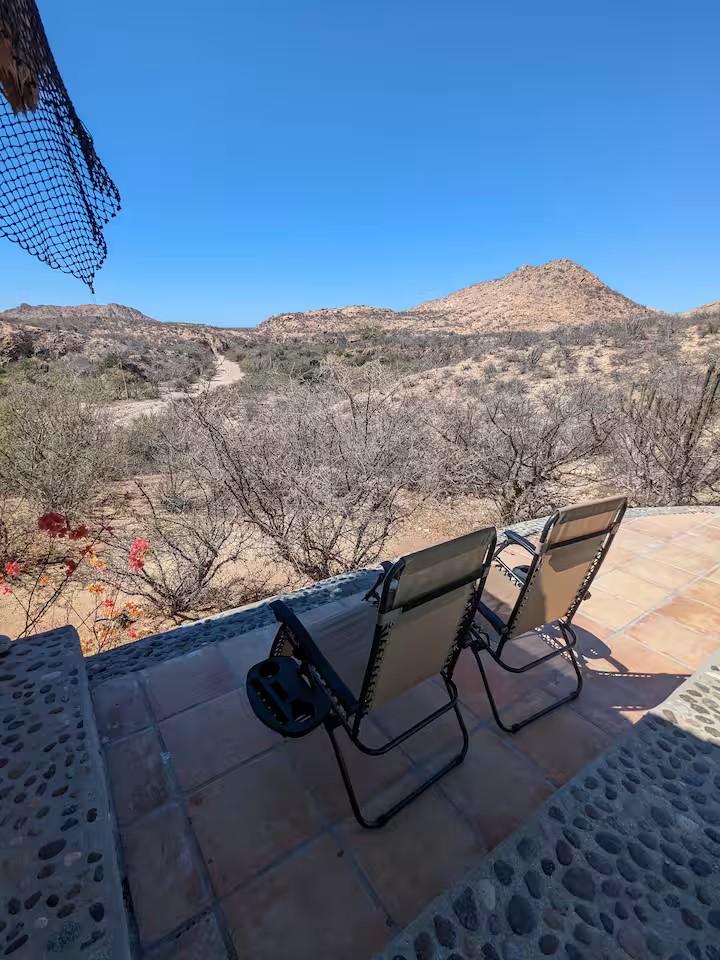Outdoor gravity chairs facing the desert landscape