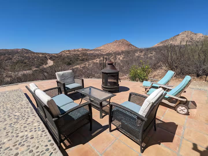 Outdoor patio with fire pit and sun loungers